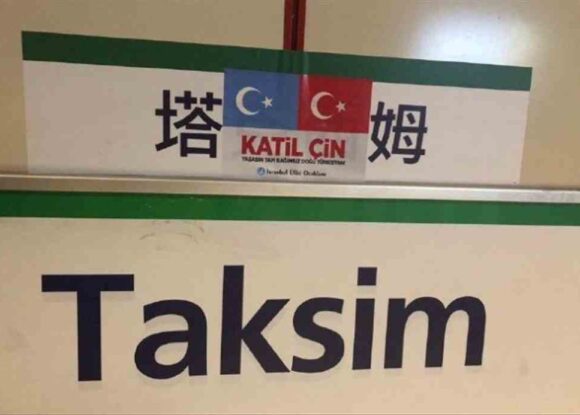 DURAKLARA ASILAN ÇİNCE TABELALARA ‘DOĞU TÜRKİSTAN’ YAPIŞTIRMALI TEPKİ